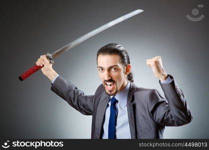 Angry businessman with sword in dark room