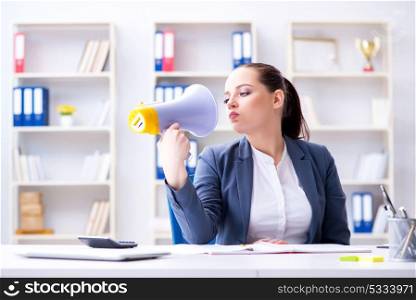 Angry businesswoman yelling with loudspeaker in office. The angry businesswoman yelling with loudspeaker in office