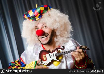 Angry clown with guitar in funny concept