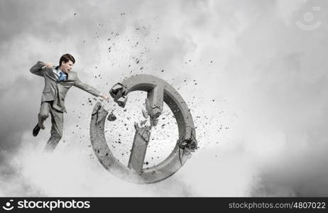 Angry determined businessman crashing stone prohibition symbol. No prohibition