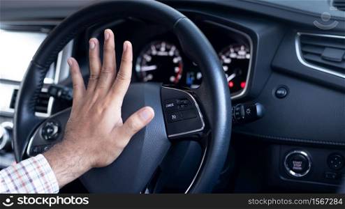 Angry driver is honking and is yelling by sitting of a steering wheel.Traffic jam.
