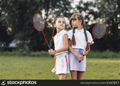 angry girls holding badminton hand looking each other