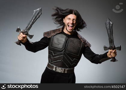 Angry knight with sword against dark background