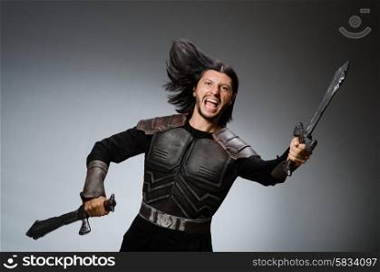 Angry knight with sword against dark background
