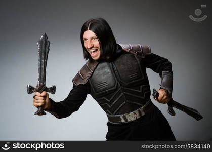 Angry knight with sword against dark background