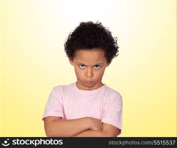 Angry latin child isolated on yellow background