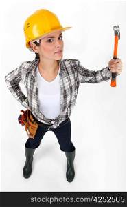 Angry looking female builder wielding hammer in the air
