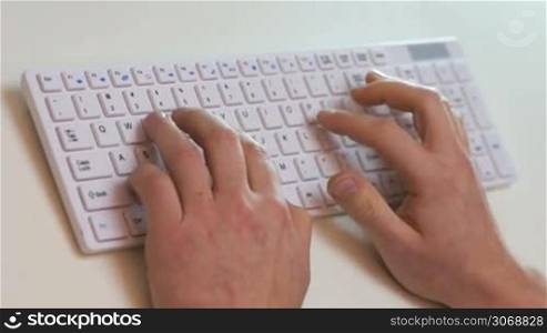 Angry man in front of computer giving a punch to keyboard