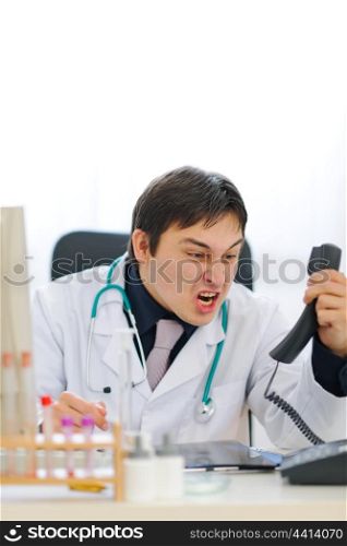 Angry medical doctor shouting in phone handset
