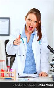 Angry medical doctor woman shouting and pointing on you&#xA;
