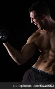 Angry muscular athlete workout biceps on black