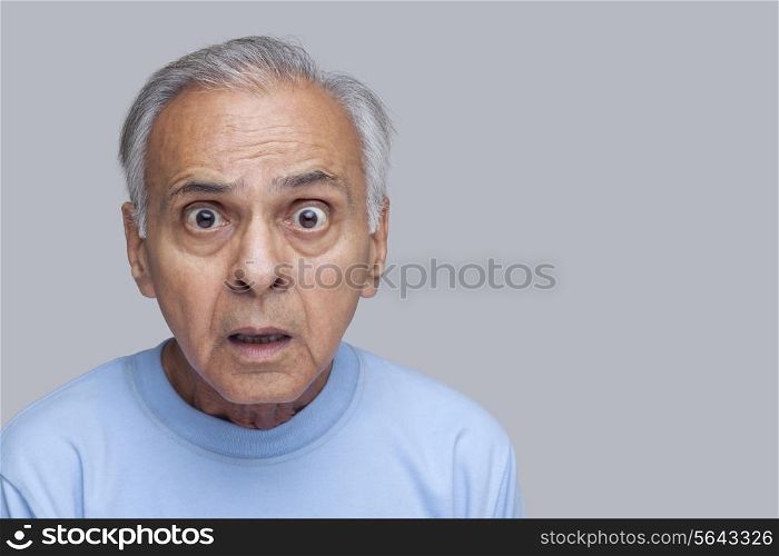 Angry old man over colored background