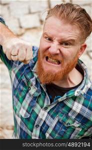 Angry red haired hipster man with blue plaid shirt