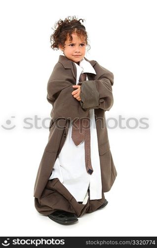 Angry three year old mixed race girl standing in baggy suit with arms crossed over white background.