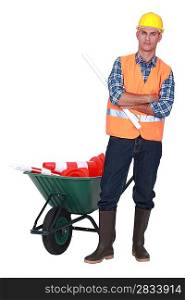 Angry tradesman standing in front of a wheelbarrow