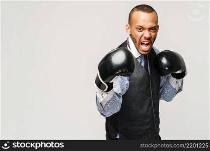 Angry upset young man office worker, business employee, fists in air with boxing gloves, open mouth yelling and shouting, negative emotion facial expression feeling.. Angry upset young man office worker, business employee, fists in air with boxing gloves, open mouth yelling and shouting, negative emotion facial expression feeling