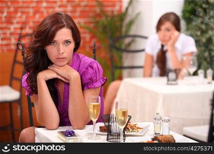 angry woman at the restaurant, on the table, an unopened gift and flutes of sparkling wine