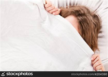 angry woman is lying in bed under blanket and doesn&acute;t want to wake up