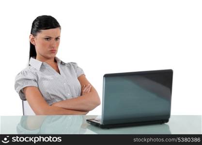 Angry woman sat with a laptop