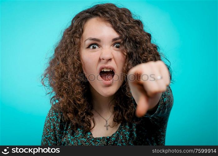 Angry woman scolding someone and pointing with her finger towards the camera