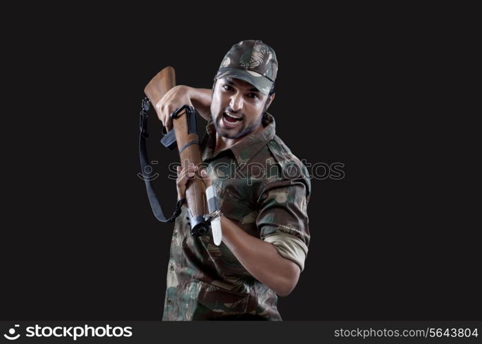 Angry young soldier holding gun