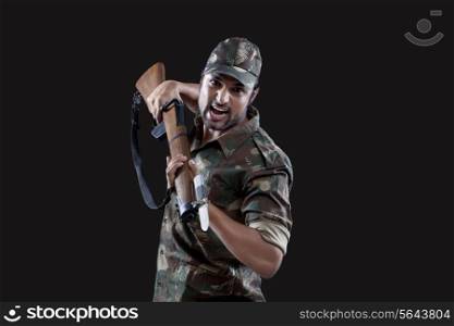 Angry young soldier holding gun