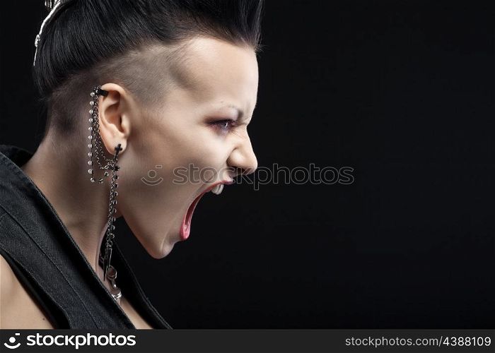 angry young woman screaming isolated on black background with copyspace