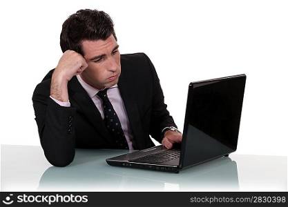 Annoyed businessman working on his laptop