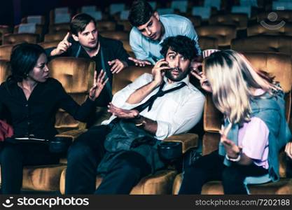 Annoying man talking on the mobile phone at the movie theater people in cinema is angry him