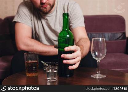 Anonymous alcoholic person hard drinking alone.