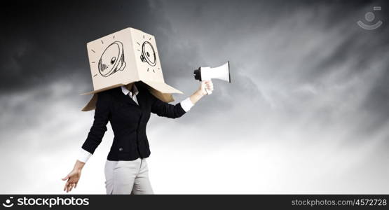 Anonymous announcement. Businesswoman wearing carton box on head and speaking in megaphone