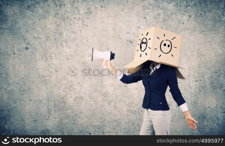 Anonymous announcement. Businesswoman wearing carton box on head and speaking in megaphone