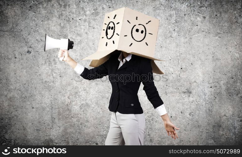 Anonymous announcement. Businesswoman wearing carton box on head and speaking in megaphone