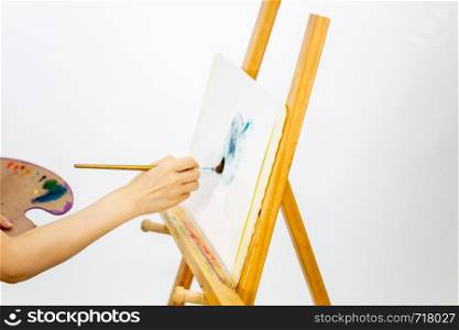 Anonymous artist painting at an easel, selective focus