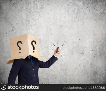 Anonymous call. Businessman using mobile phone wearing carton box on head