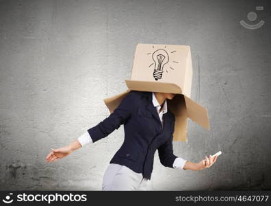 Anonymous call. Businesswoman using mobile phone wearing carton box on head