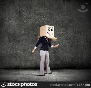 Anonymous call. Businesswoman using mobile phone wearing carton box on head