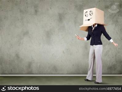 Anonymous call. Businesswoman using mobile phone wearing carton box on head