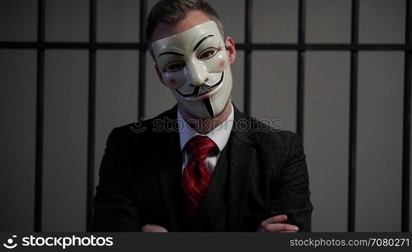 Anonymous hacker in prison has head tilted with attitude