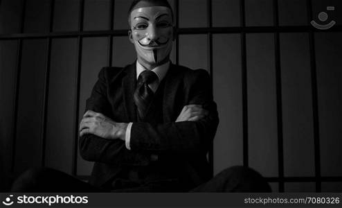 Anonymous hacker in prison with arms crossed (B/W Version)