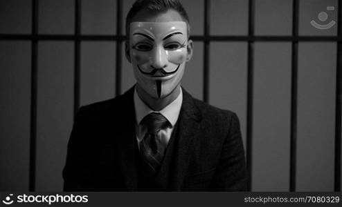 Anonymous hacker man sighes in prison (B/W Version)