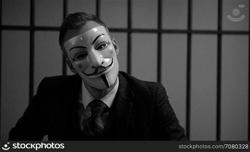 Anonymous hacker tilts head in prison (B/W Version)