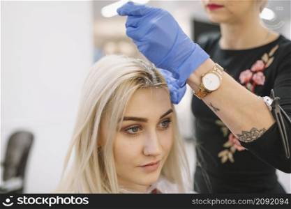 anonymous hairdresser coloring hair young blonde