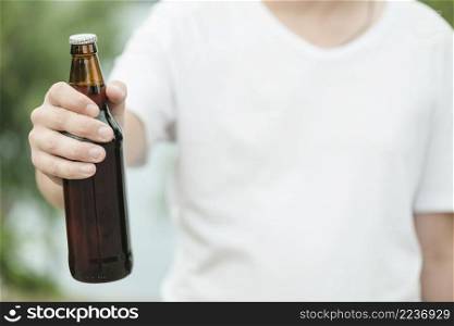 anonymous man showing bottle beer