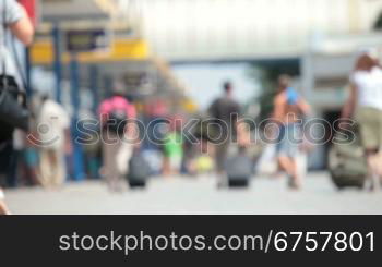 anonymous people with suitcases walk along the station platform