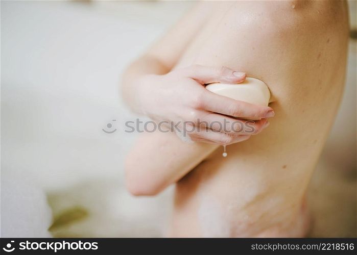 anonymous woman taking bath with soap