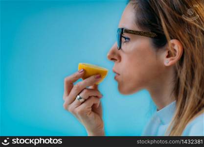 Anosmia or smell blindness, loss of the ability to smell, one of the possible symptoms of covid-19, infectious disease caused by corona virus. Woman Trying to Sense Smell of a Lemon. Anosmia or smell blindness, loss of the ability to smell