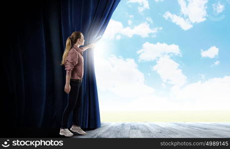 Another reality. Young woman in casual opening blue curtain