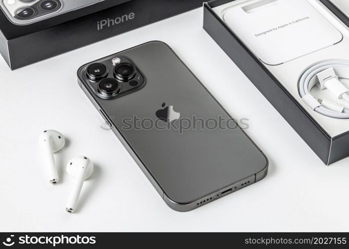 Antalya, Turkey - November 30, 2021: Back view of new iPhone 13 Pro smartphone and Apple Airpods 2 earphone.