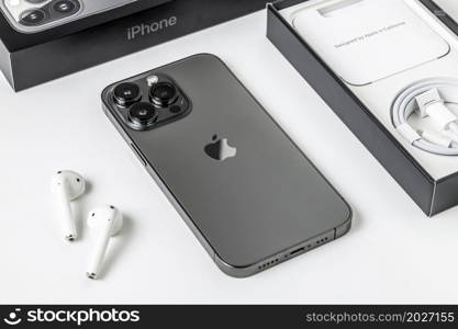 Antalya, Turkey - November 30, 2021: Back view of new iPhone 13 Pro smartphone and Apple Airpods 2 earphone.